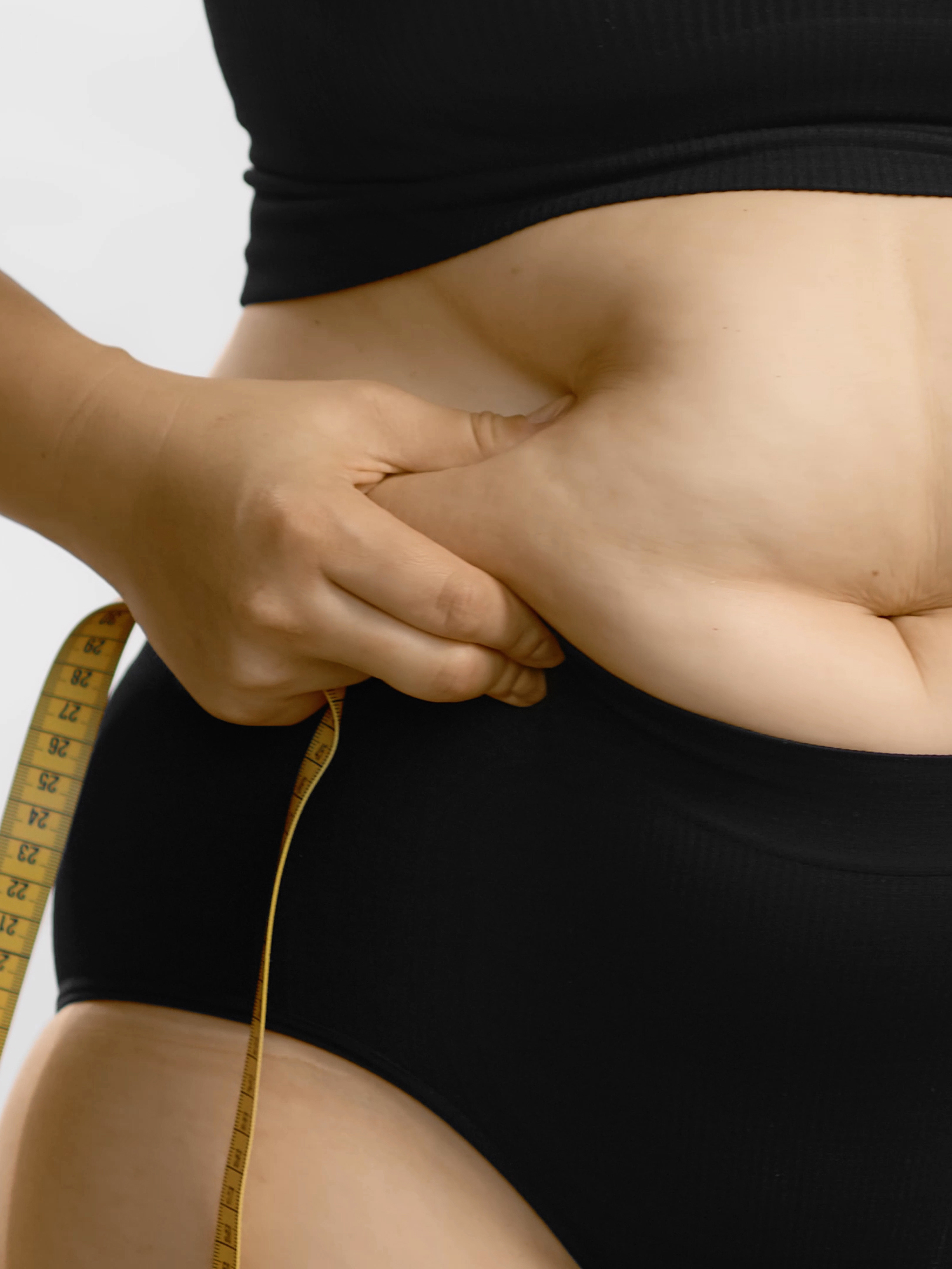 Woman body fat belly. Obese woman hands holding excessive tummy fat. Change diet lifestyle concept to shape up healthy stomach muscle. Studio anonymous shot photo of body parts.